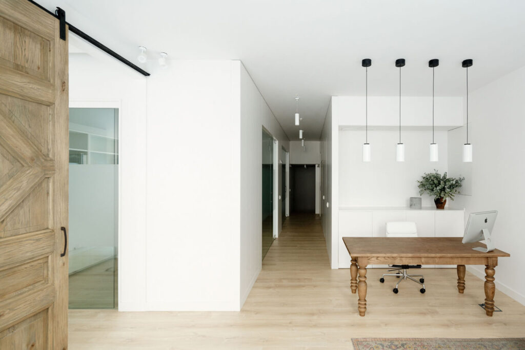 Pasillo con varias estancias y una mesa de recepción en primer plano